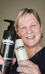 Woman holding two bottles of Lustrao hair care products against a plain background